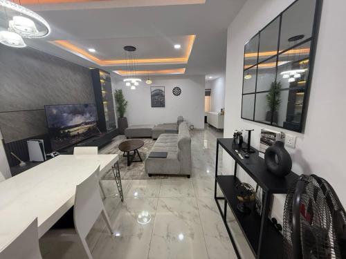 Una gran sala de estar con un sofá y un televisor. en Home Habor Properties, en Lekki