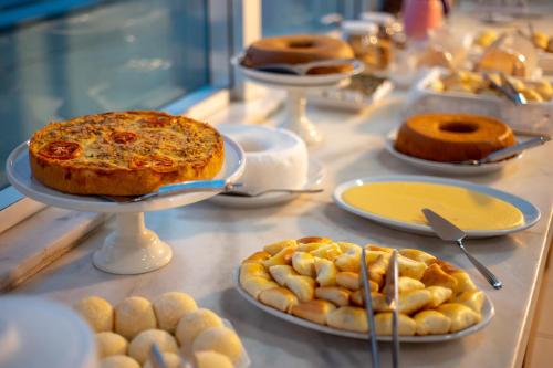 a buffet with plates of food on a table at Iguatemi Business & Flat by Avectur in Salvador