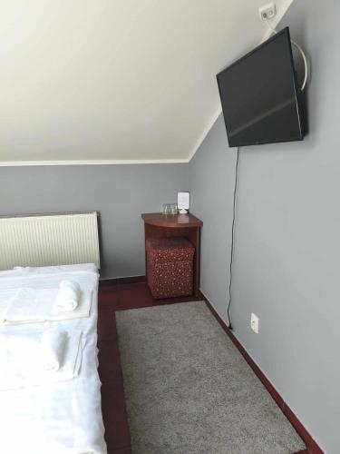 a room with two beds and a tv on the wall at Centrum Konferencyjne Sułtan in Marki