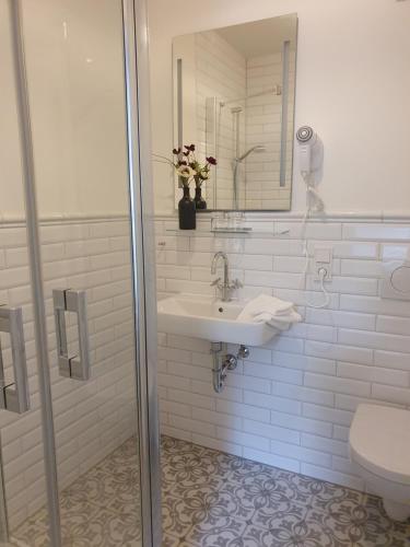 a bathroom with a sink and a mirror and a toilet at Boutique Hotel Villa Horbach in Idar-Oberstein