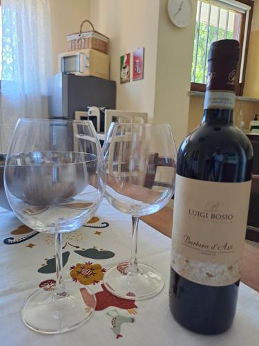a bottle of wine and two wine glasses on a table at La Casa di Simone in SantʼAmbrogio di Torino