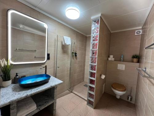 a bathroom with a blue sink and a shower at Martini Fishing Camp in Lauvsnes