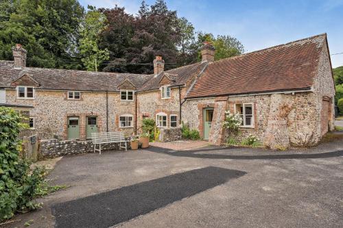an old stone house with a bench in front of it at Cub Bedroom Six in Eastdean