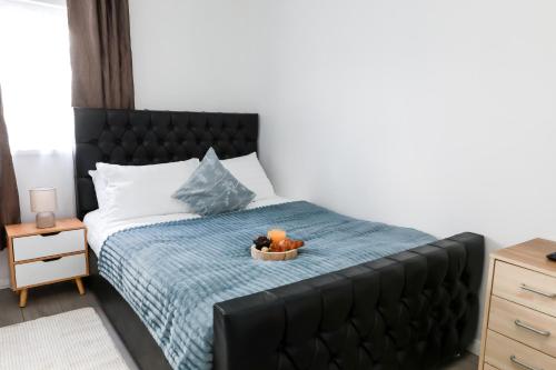 a bedroom with a bed with a bowl of fruit on it at 4 Guests - 2 Bedrooms - City Escape Retreat in Stoke on Trent