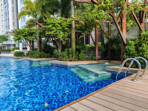 a swimming pool with blue water and trees in a building at Azzahra Homestay Masai Pasir Gudang in Masai