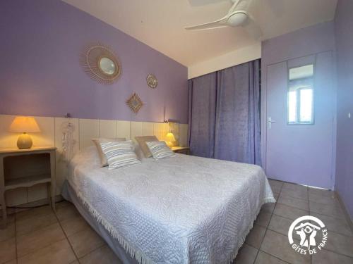 a bedroom with a white bed and purple walls at Le tilleul du parc de la dame in Latour-Bas-Elne