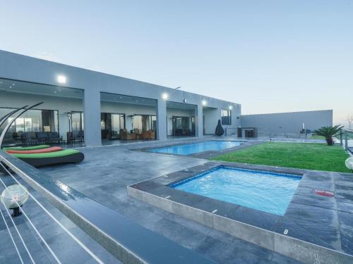 a house with a swimming pool in front of it at Humdani Safaris Free State in Virginia