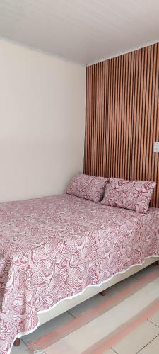 a bedroom with a bed with pink sheets and pillows at Espaço Sol e Mar in Salvador