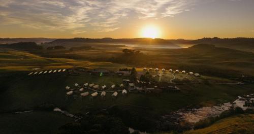 an aerial view of a resort with the sun setting in the background at Parador Cambará do Sul in Cambara do Sul