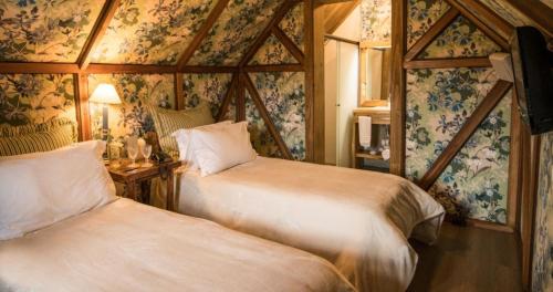 two beds in a room with floral wallpaper at Parador Cambará do Sul in Cambara do Sul