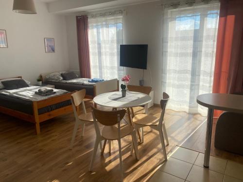 a living room with a table and chairs and a bedroom at Apartament Bażantowo z parkingiem in Katowice