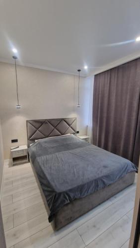 ein Schlafzimmer mit einem großen Bett mit einer grauen Decke in der Unterkunft 1 комн квартира в Кадоре на Таирова in Odessa