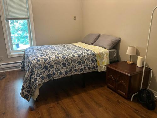 a bedroom with a bed and a table and a window at Maple Tree Oasis 2 bedroom in Pickering in Pickering