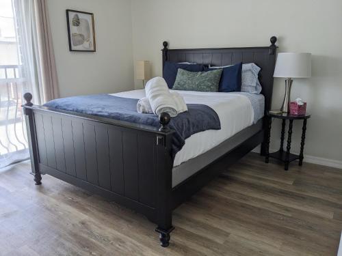 a bedroom with a large black bed with blue pillows at Shortest Walk to Shands and UF Health - Quiet, Equipped, Reliable - Free Parking in Gainesville