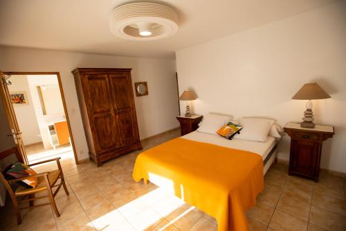 a bedroom with a bed with an orange blanket at Les Villas de Perret in Joyeuse
