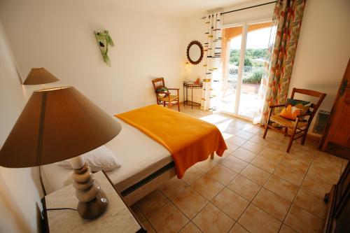 a bedroom with a bed and a lamp on a table at Les Villas de Perret in Joyeuse