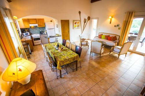 a kitchen and living room with a table and chairs at Les Villas de Perret in Joyeuse