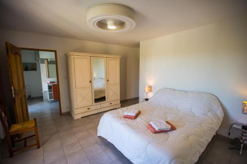 a bedroom with a bed with two towels on it at Les Villas de Perret in Joyeuse