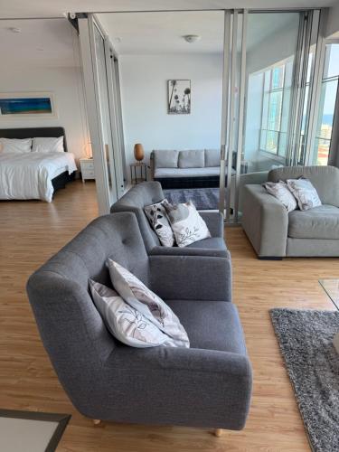 a living room with two couches and a bed at Coastal Dreamscape in Gold Coast