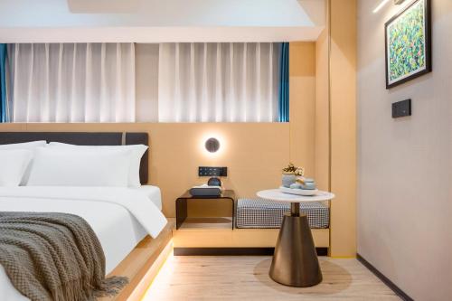 a hotel room with a bed and a table at Kainuo Garden Aesthetic Design Hotel Beijing Road - Shisanhang - Railway Station Metro Station - International Trade Center, Yuexiu District Guangzhou-- Reputation Preferred in Guangzhou
