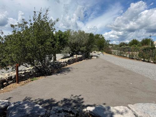 an empty road with trees and a stone wall at Les Villas de Perret in Joyeuse