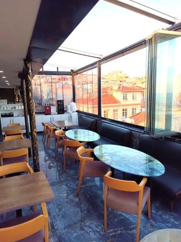 a restaurant with tables and chairs and windows at RoyalBoutique Hotel Anex B KayaRoyal - There is No Lift - All Coffees & Tea Free Of Charge At The Terrace Restaurant in Istanbul