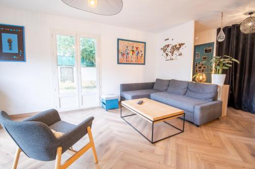 a living room with a couch and a table at Séjour haut en couleurs in Cormery