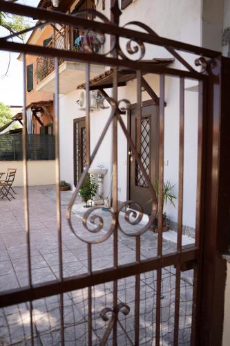 a view through a wrought iron gate into a courtyard at la casa di fatima in Campoleone