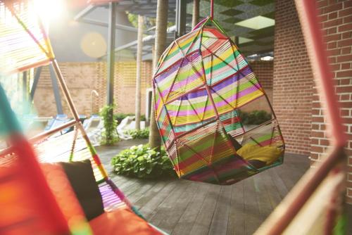 a colorful kite hanging from a porch swing at Oasia Hotel Downtown, Singapore by Far East Hospitality in Singapore