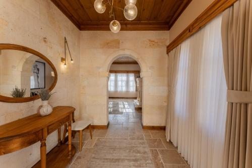 a hallway with a mirror and a table in a room at Asmalı Konak Cave Suites in Urgup