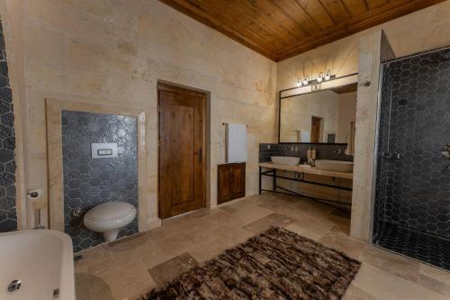 a bathroom with a toilet and a sink and a mirror at Asmalı Konak Cave Suites in Urgup
