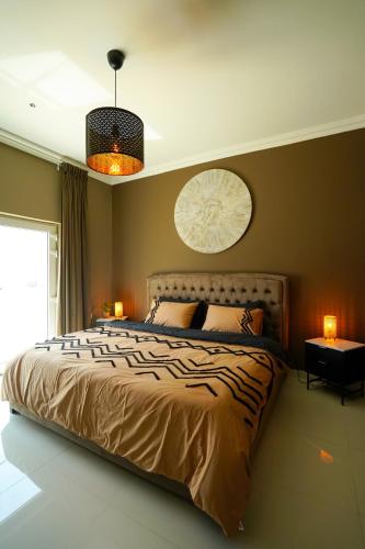 a bedroom with a bed with two lamps and a clock at Maison Miraj Hostel in Muscat