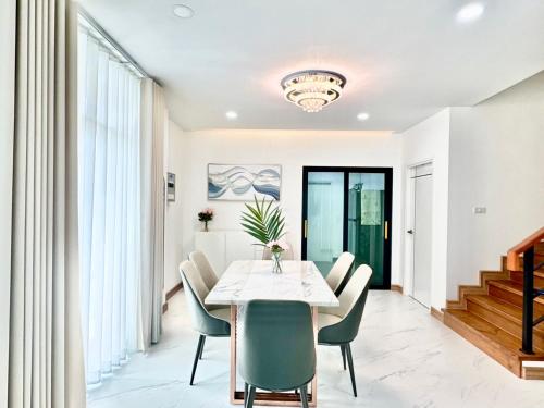a dining room with a white table and chairs at CORNER STAY 210 Hatyai in Sathani Khlong Rian