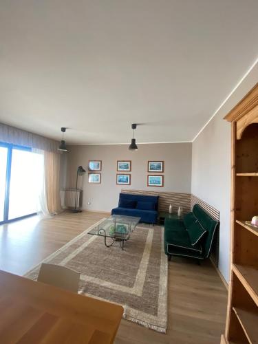 a living room with a blue couch and a table at Attico fronte mare con terrazzo in Pescara