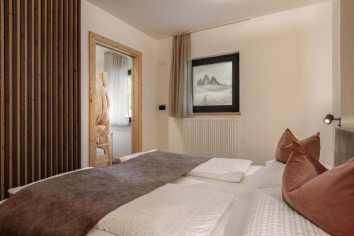 a bedroom with a large bed and a window at Aparthotel Familiaris - Family Apartments - Pools & Spa in Dolomites in Valdaora