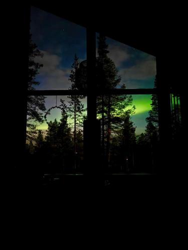 a view of a sunset through a window at Villa Arctic Trail B - Lapland Escape with Outdoor Hot Tub & Ylläs Ski Passes in Äkäslompolo