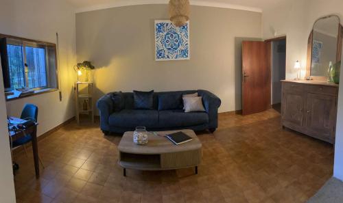 un soggiorno con un divano blu e un tavolo di Casa Da Alice a Duas Igrejas