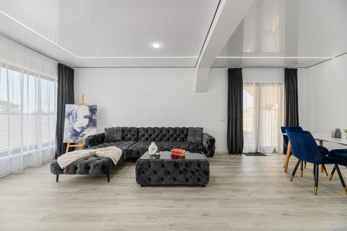 un soggiorno con un divano nero e un tavolo di KOA - Street a Braşov