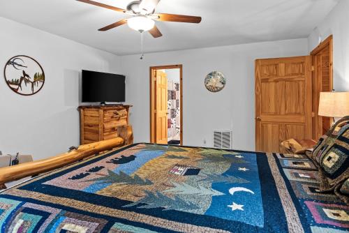 a bedroom with a bed and a ceiling fan at The Cabin Kingdom Hot tub Fire Pit in Blairsville