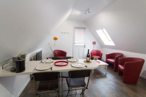 a dining room with a table and red chairs at ENTRE LOIRE ET CHER "Les Bruyères" Gîte & SPA Privatif in Tour-en-Sologne
