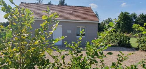 a gray house with a window in a yard at ENTRE LOIRE ET CHER "Les Bruyères" Gîte & SPA Privatif in Tour-en-Sologne