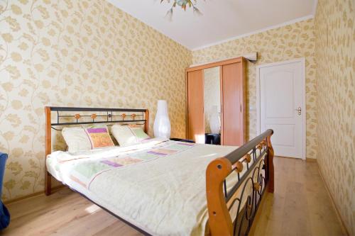 a bedroom with a large bed with a wooden frame at Apartment next to Kazan Cathedral in Saint Petersburg