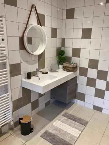 une salle de bains avec un lavabo et un miroir dans l'établissement L'escapade, à La Celle-sous-Gouzon