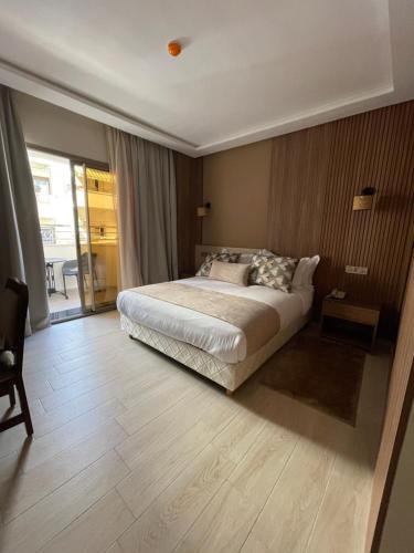 a bedroom with a bed and a large window at Hotel De Nice in Meknès