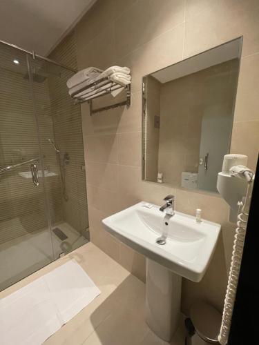 a bathroom with a sink and a shower and a mirror at Hotel De Nice in Meknès