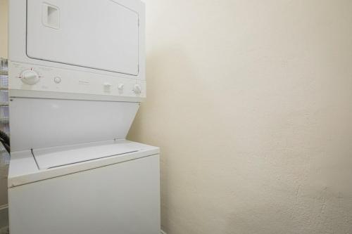 a white refrigerator with a microwave on top of it at Classic City Apartment w Firepit in Athens