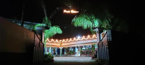 a building with a gate at night with lights at Pauls Retreat Wayanad in Wayanad