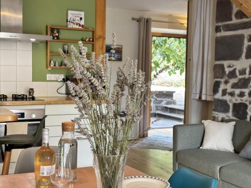 a vase of flowers on a table in a kitchen at L'Écrin Volvicien - Maison 4 pers - Terrasse - Jardin in Volvic