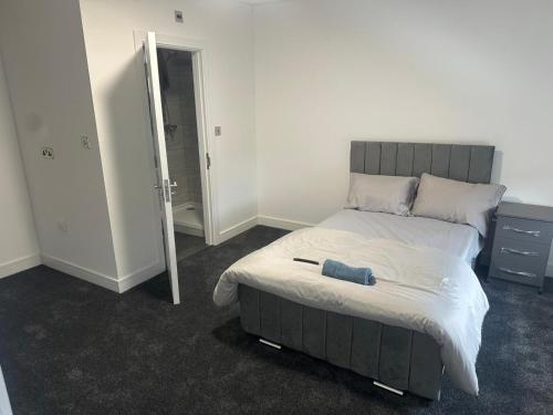 Un dormitorio con una cama grande con una toalla azul encima. en Luton Room only, en Luton