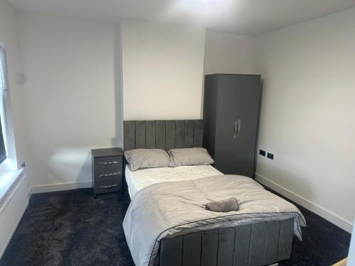 Un dormitorio con una cama con un animal de peluche encima. en Luton Room only, en Luton